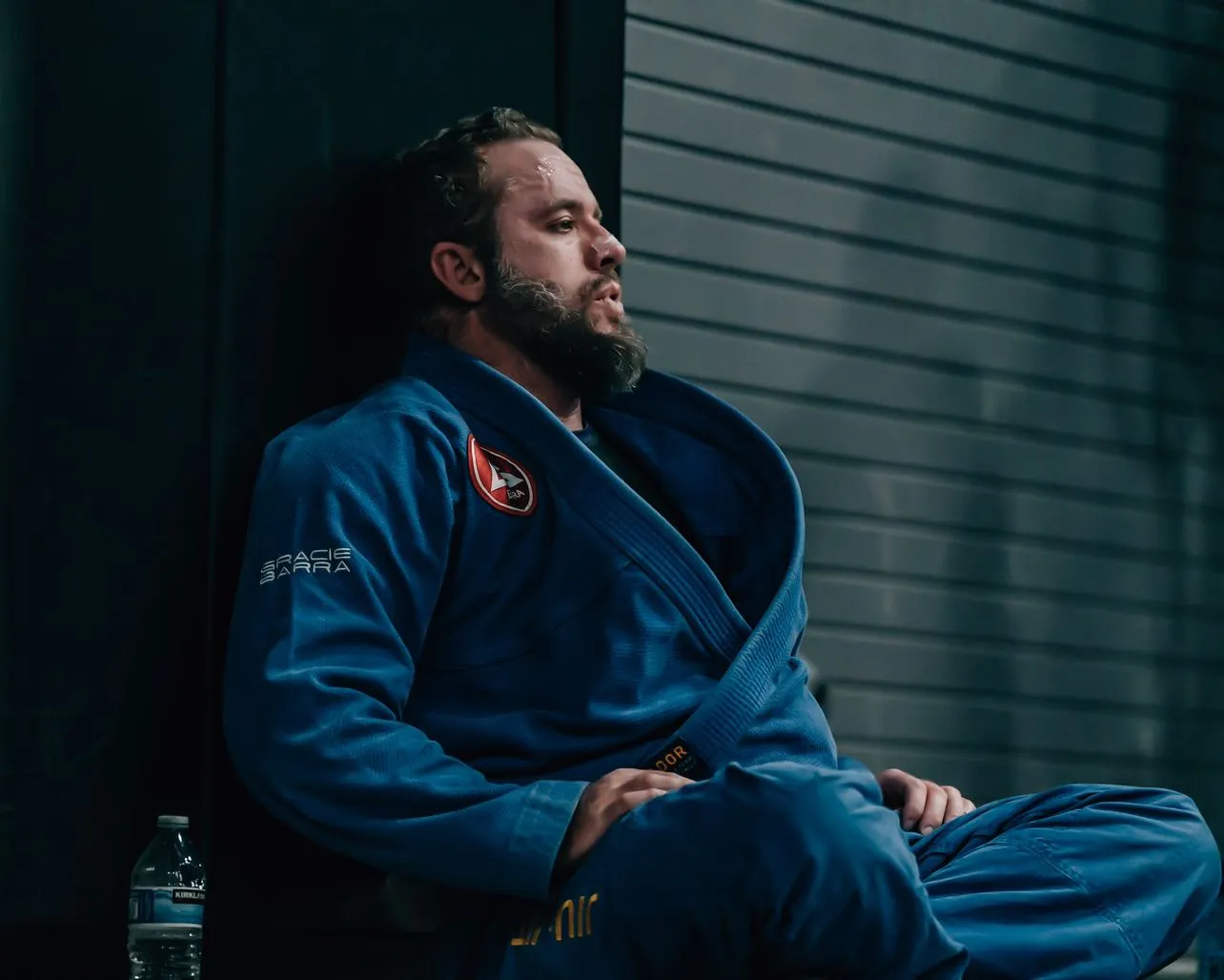 Spencer Hornock seated in a blue Brazilian Jiu-Jitsu gi
